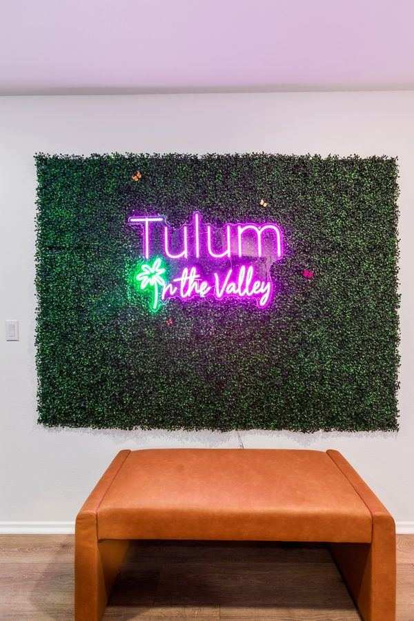 Tulum in the Valley neon sign — branded living room feature wall